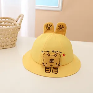 Close-up of yellow baby sun hat with plush cartoon tiger and 3D bear ears