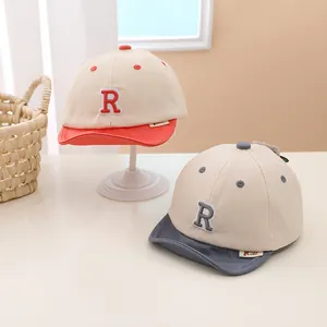 Close-up of baby baseball caps featuring letter R embroidery and soft short brims