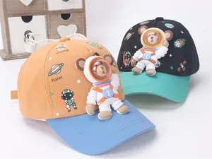 Detail of children's baseball caps featuring 3D astronaut bears and contrast color brims