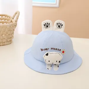 Detail of light blue baby sun hat featuring 3D cartoon bear decor and bear hoase embroidery