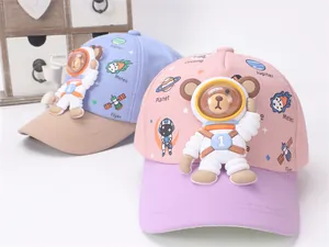 Close-up of 3D silicone space bear on blue and pink baseball caps for kids