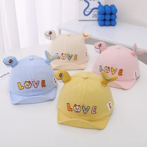 Detalle de cuatro gorras de béisbol para bebés con bordados de dibujos animados suaves