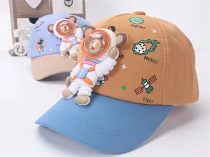 Detail of kids baseball caps featuring 3D astronaut bear and space theme patterns