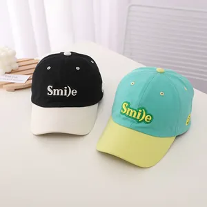 Detailed view of kids Smile embroidery and color-block stitching on cotton baseball caps