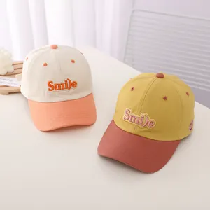 Detail of Smile letter embroidery and cotton fabric texture on kids baseball caps