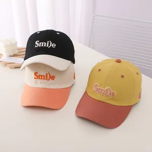 Trio of kids' two-tone baseball caps with 'Smile' embroidery in various vibrant colors