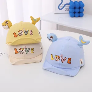 Detalle de gorras de béisbol para bebé con visera blanda y bordados de peces y la palabra LOVE