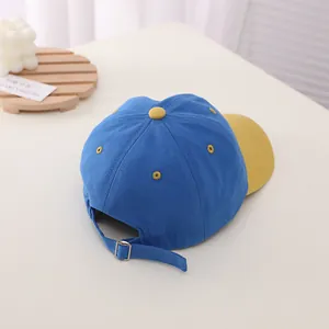 Detail view of the adjustable metal buckle and contrast color back of the kids baseball cap