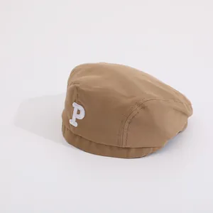 Detail der khakifarbenen Kinder-Schirmmütze mit weißer 3D-bestickter P-Logo-Applikation