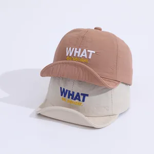 Detail of two quick-dry baseball caps in beige and tan with WHAT letter embroidery