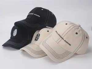 Detail of embroidered letters and contrast stitching on children cotton baseball caps