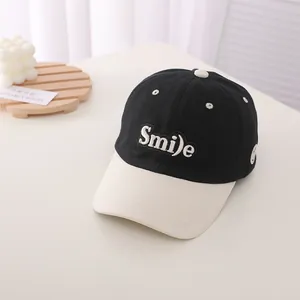 Detailed view of the Smile embroidery and contrast bill on this cotton baseball cap