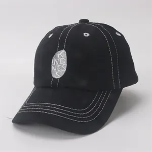 Close-up of a black cotton kids baseball cap featuring white contrast stitching detail