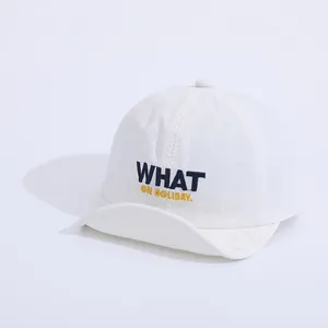 Detailed view of white soft-brim kids baseball cap with WHAT ON HOLIDAY embroidery