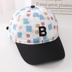 Detail of white cotton baseball cap showing vibrant smiley patterns and 3D embroidered B letter