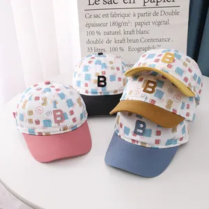 Close-up of children's baseball caps with letter B embroidery and colorful smile prints