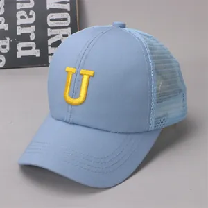 Close-up of baby blue mesh cap with yellow embroidered letter U and detailed stitching