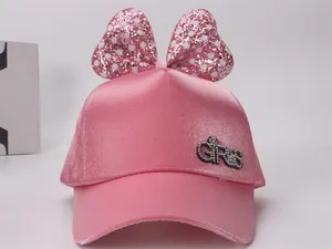 Détail de casquette satin rose avec nœud à paillettes et strass pour filles