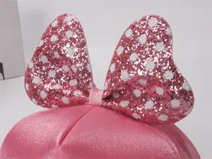 Gros plan du nœud à paillettes rose à pois blancs sur une casquette pour fille
