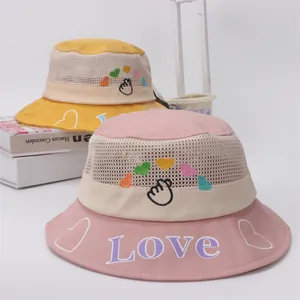 Detail of pink and yellow sun hats with breathable mesh and heart embroidery