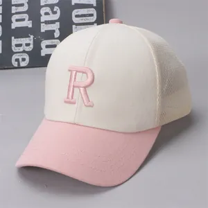 Detail of pink embroidered letter R on breathable mesh summer baseball cap for kids