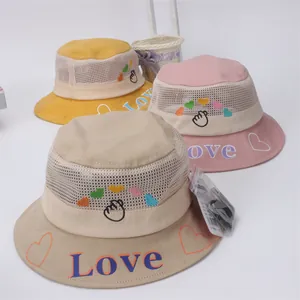 Close-up of children mesh sun hats in yellow, pink and beige with Love embroidery