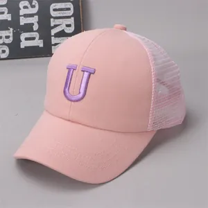 Detailed close-up of pink mesh baseball cap with purple letter U embroidery for kids