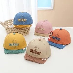 Détail de casquettes de baseball pour bébé avec broderie ours et blocs de couleurs