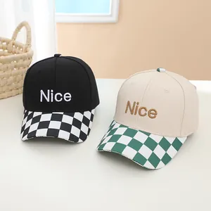 Detail of kids baseball caps featuring 'Nice' embroidery and checkerboard pattern brims