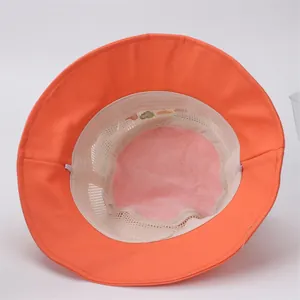 Detail of orange sun hat featuring breathable white mesh lining and heart embroidery