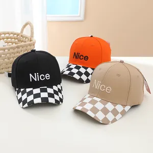 Close-up of three baseball caps with 'Nice' embroidery and checkered visors on a desk