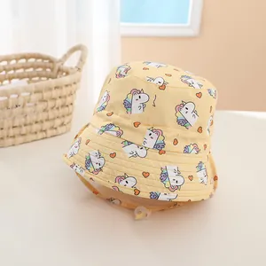 Detail of yellow cotton bucket hat for toddlers featuring unicorn and heart patterns