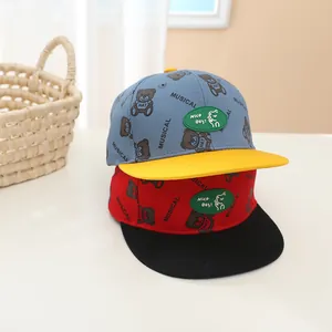 Détail de casquettes enfant avec ours cartoon, lettres brodées et patch Nico Day!