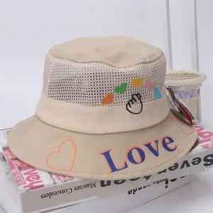 Detail of baby sun hat featuring breathable mesh top and colorful love heart embroidery