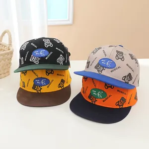 Détail de quatre casquettes de baseball pour enfants avec motifs d'ours et imprimés
