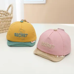 Détail de casquette bébé avec broderie secret et illustration d'ours mignon