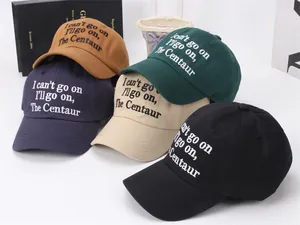 Detail of embroidered lettering and stitching on various colors of cotton baseball caps