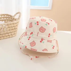 Detail of baby bucket hat featuring bear and cherry prints with adjustable chin strap