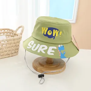 Detail view of kids green sun hat with WOW letters, cartoon dinosaur and adjustable strap