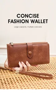 Détail portefeuille vintage en cuir marron avec dragonne et fermeture éclair métal