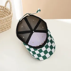 Detail of checkered baseball cap with purple lining and reinforced internal structure