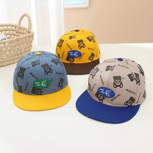 Détail de trois casquettes pour enfants en coton avec motifs ours et écusson NICO Day