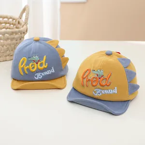 Detail of dinosaur-themed cotton baseball caps with cartoon embroidery and 3D fabric scales