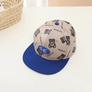 Détail de la casquette enfant avec motif dinosaure, écusson NICO DAYS et visière bleue