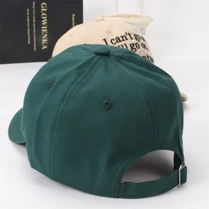 Detail of adjustable metal buckle and stitching on dark green cotton baseball cap