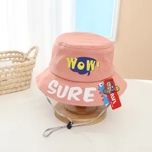 Detail of pink cotton sun hat featuring WOW lettering and a blue cartoon dinosaur pattern