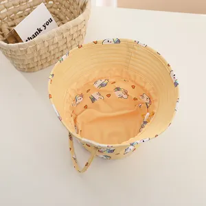 Detail of yellow cotton toddler bucket hat featuring colorful unicorn and heart prints