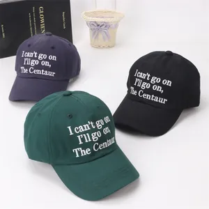 Detail of embroidered cotton baseball caps in dark green, navy blue, and black colors