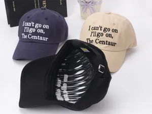 Detail view of cotton baseball caps with letter embroidery and metal buckle closure