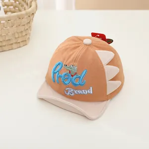 Close-up of baby dinosaur baseball cap featuring dinosaur spikes and crocodile embroidery